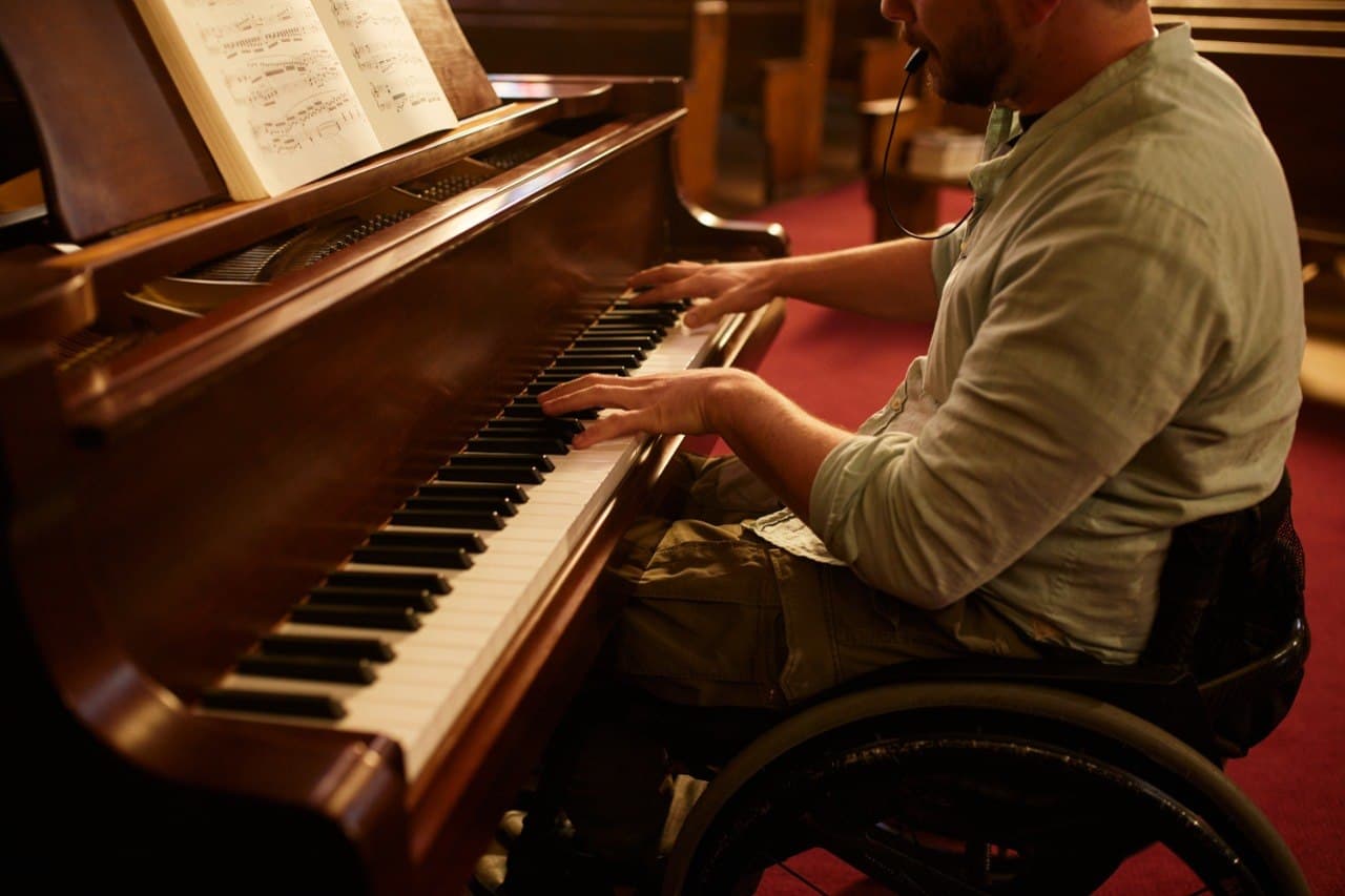 Riccardo playing piano in a wheelchair